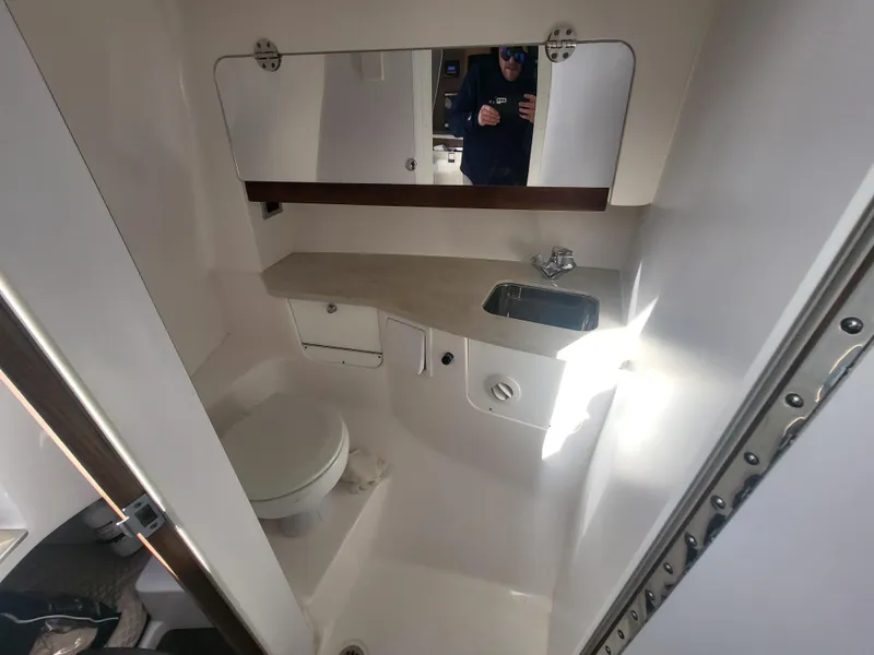 Slide: The Image of 2018 Everglades 360 LXC boat bathroom with sink, toilet, and mirror. - 29