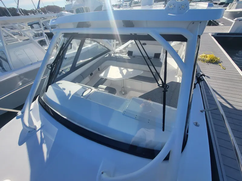 Slide: The Image of 2018 Everglades 360 LXC boat docked, front view through windshield. - 34