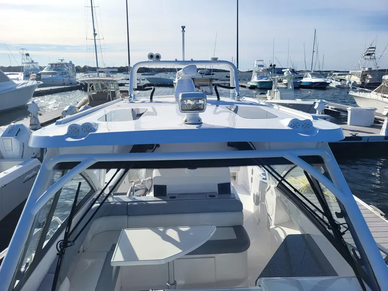 Slide: The Image of 2018 Everglades 360 LXC boat docked at a marina with other boats. - 37