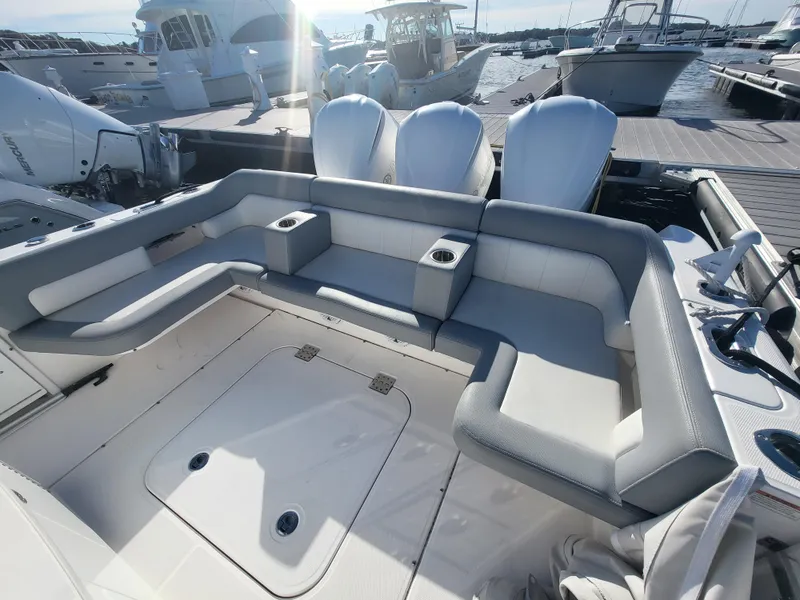 Slide: The Image of 2018 Everglades 360 LXC boat with spacious seating and triple outboard engines at a marina. - 46