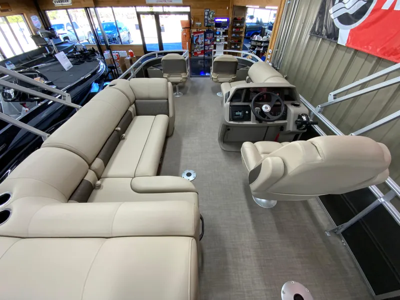Slide: The Image of 2024 Sun Tracker Fishin' Barge 20 DLX interior with beige seating and steering console. - 14
