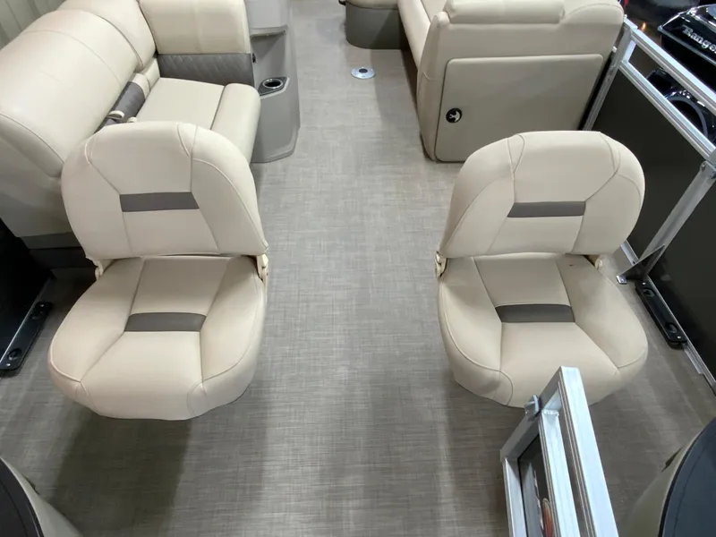 Slide: The Image of 2024 Sun Tracker Fishin' Barge 20 DLX interior with beige seating and carpeted floor. - 6