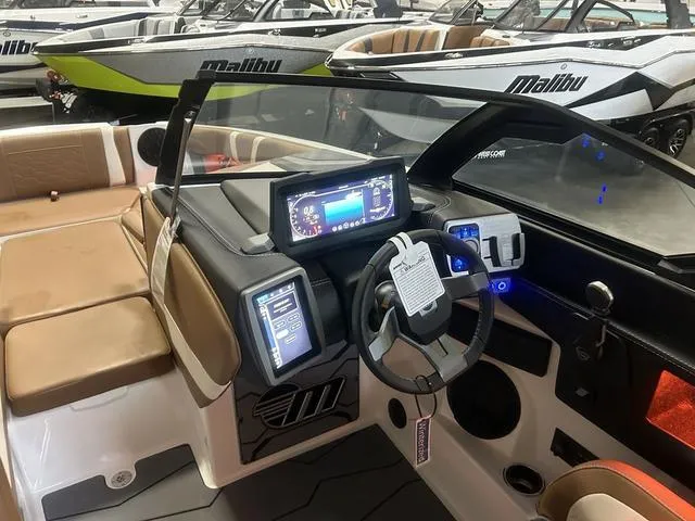 Slide: The Image of 2024 Malibu 23 MXZ boat interior with advanced dashboard and seating. - 12