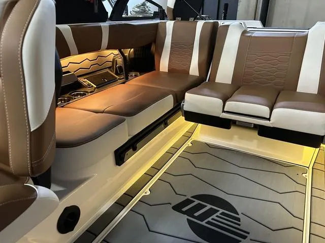 Slide: The Image of Luxurious interior of the 2024 Malibu 23 MXZ boat with brown and white leather seats. - 13