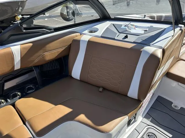 Slide: The Image of 2024 Malibu 23 MXZ boat interior with brown and white leather seating. - 14