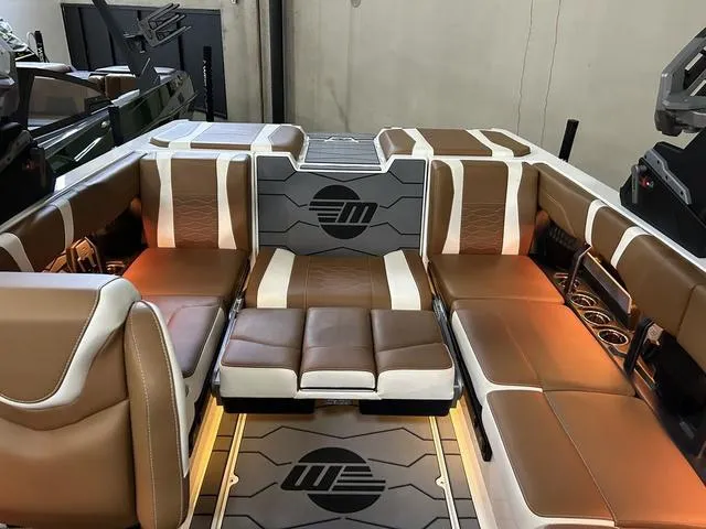 Slide: The Image of 2024 Malibu 23 MXZ boat interior with brown and white leather seating. - 15