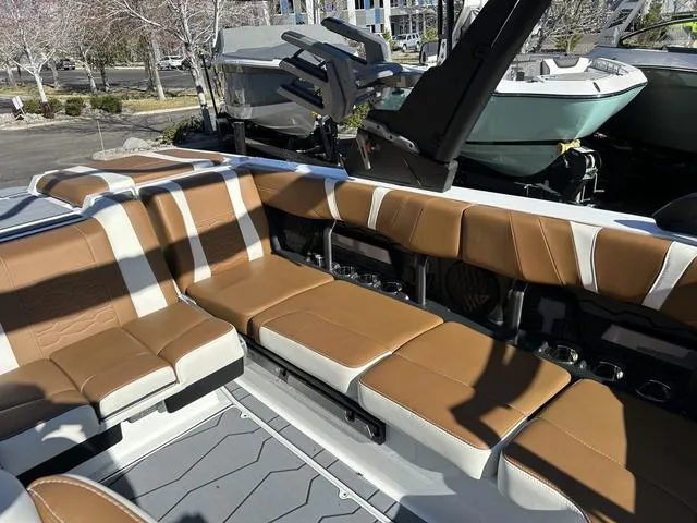 Slide: The Image of 2024 Malibu 23 MXZ boat interior with tan and white seating. - 19