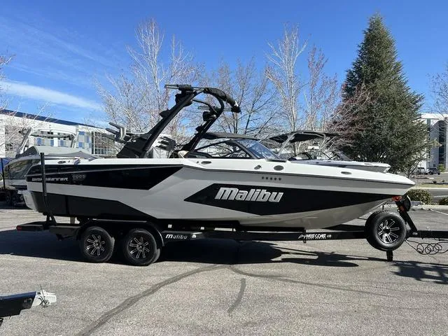 Slide: The Image of 2024 Malibu 23 MXZ boat on trailer in outdoor setting. - 4