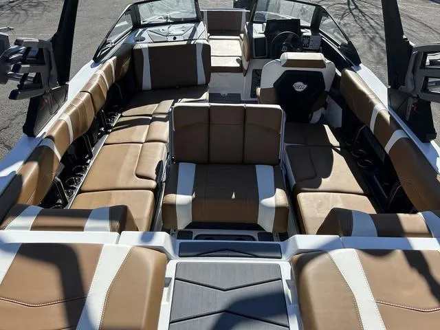 Slide: The Image of 2024 Malibu 23 MXZ boat interior with brown and white seating. - 7