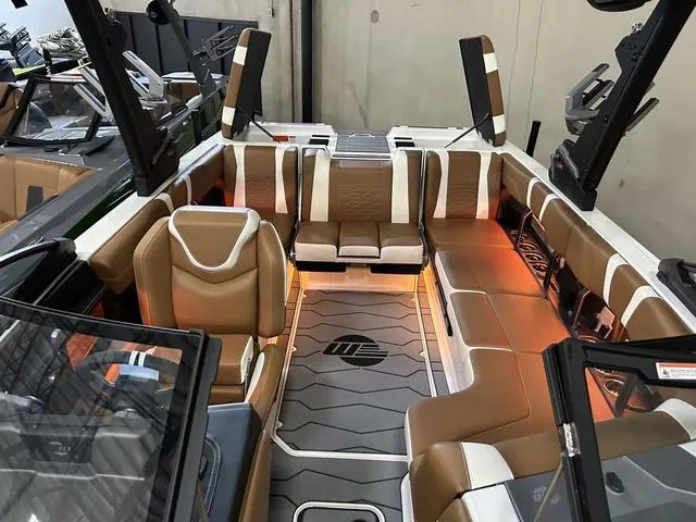 Slide: The Image of 2024 Malibu 23 MXZ boat interior with brown and white seating, illuminated floor. - 8