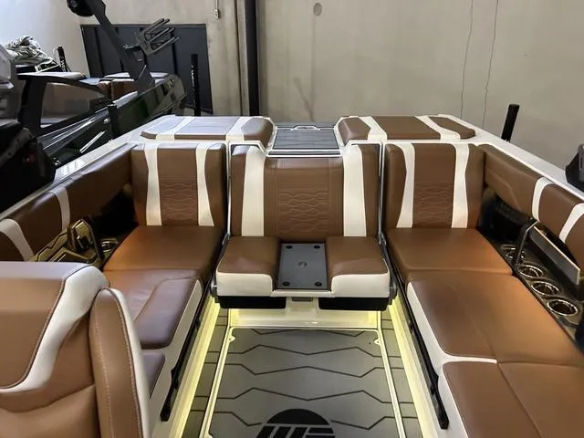 Slide: The Image of 2024 Malibu 23 MXZ boat interior with brown and white seating. - 9