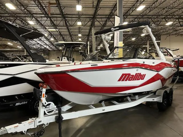 Slide: The Image of 2024 Malibu 22 LSV boat in showroom, red and white design, on trailer. - 1