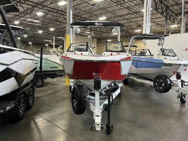 Slide: The Image of 2024 Malibu 22 LSV boat in showroom, front view, red and white color. - 2