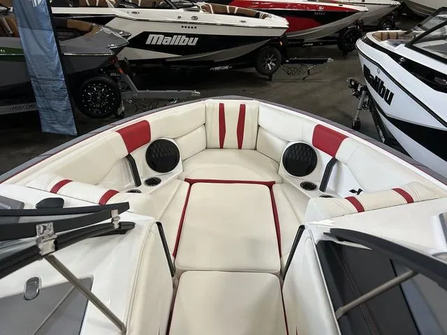 Slide: The Image of 2024 Malibu 22 LSV boat interior with white and red seating, speakers, and cup holders. - 7