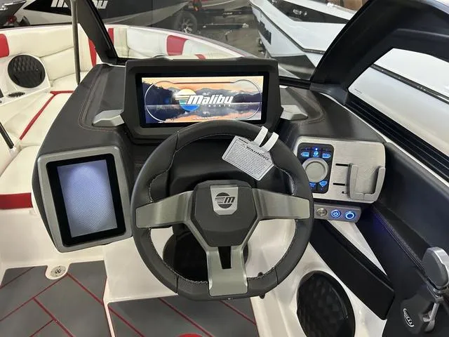 Slide: The Image of 2024 Malibu 22 LSV boat dashboard with touchscreen controls and steering wheel. - 9