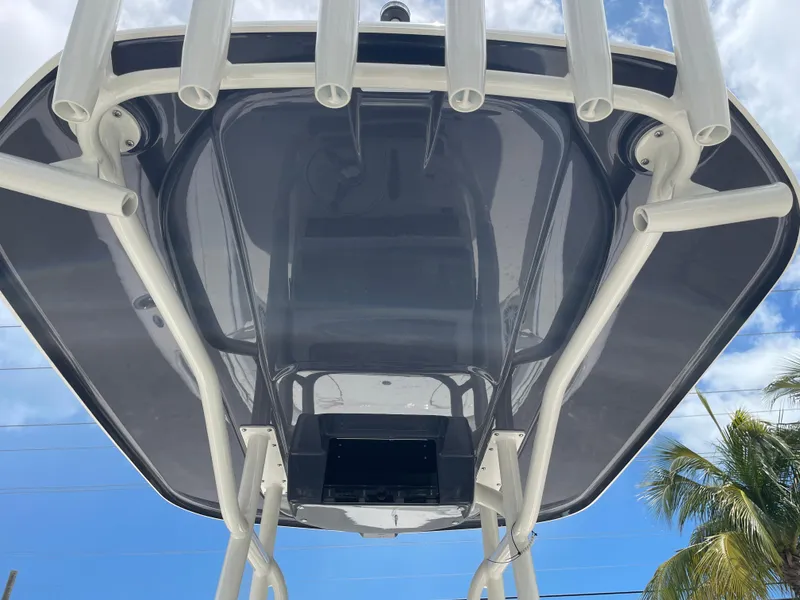 Slide: The Image of 2022 Skeeter 2550 Family boat T-top with rod holders against blue sky. - 11