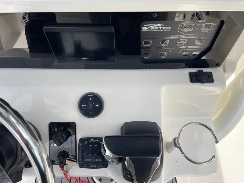 Slide: The Image of Control panel of a 2022 Skeeter 2550 Family boat with steering wheel and electronic controls. - 22