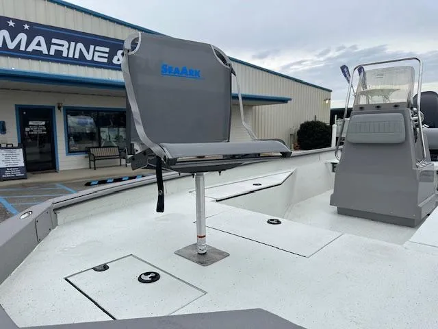 Slide: The Image of 2024 SeaArk Bay Runner 210 boat with seating, displayed at a marine dealership. - 8