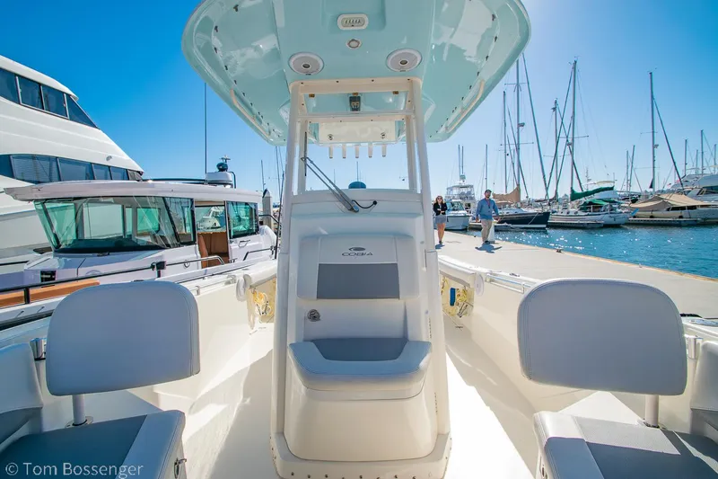 Slide: The Image of 2018 Cobia 240 CC boat docked at marina, surrounded by yachts and clear blue sky. - 11