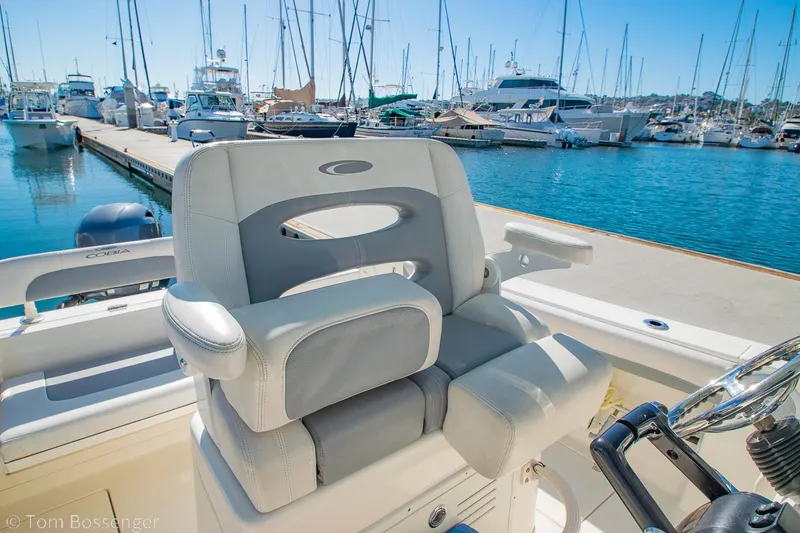 Slide: The Image of 2018 Cobia 240 CC boat seat at marina with yachts in background. - 12