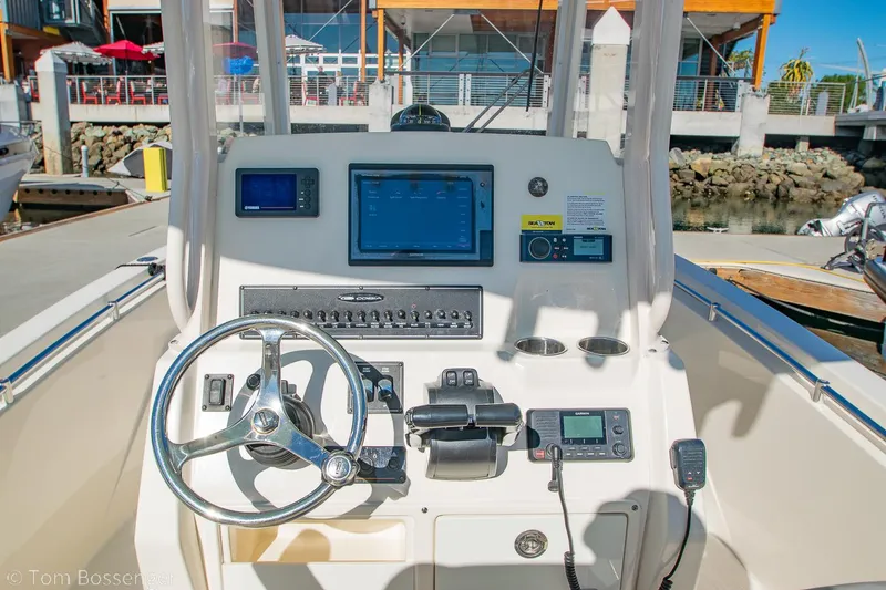 Slide: The Image of 2018 Cobia 240 CC boat dashboard with steering wheel and navigation controls. - 14
