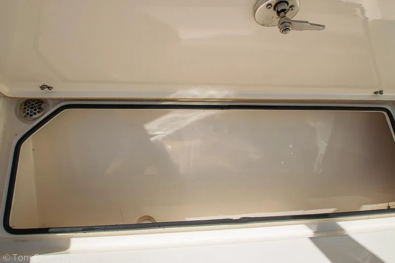 Slide: The Image of 2018 Cobia 240 CC boat storage compartment with latch, open and empty. - 24