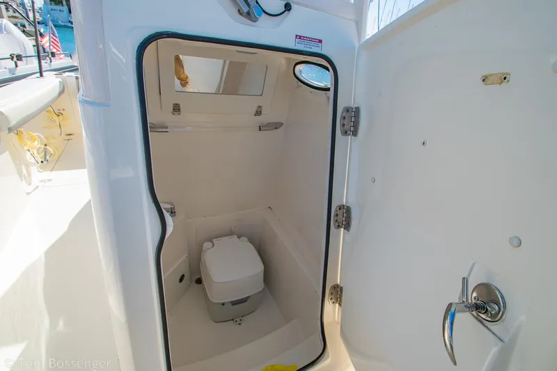 Slide: The Image of 2018 Cobia 240 CC boat interior with compact marine toilet. - 25