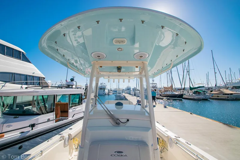 Slide: The Image of 2018 Cobia 240 CC boat docked at a marina under clear blue skies. - 27