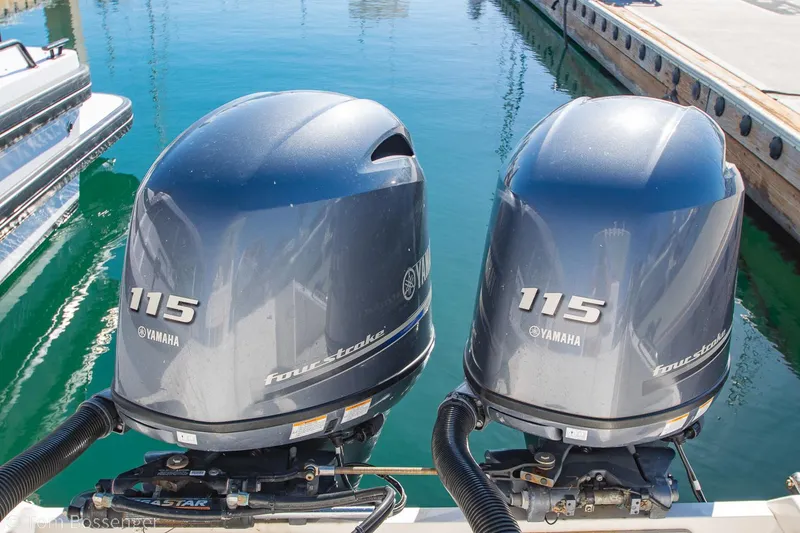 Slide: The Image of Twin Yamaha 115 outboard motors on a 2018 Cobia 240 CC boat at a marina. - 28