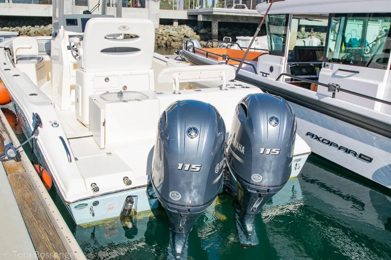 Slide: The Image of 2018 Cobia 240 CC boat with twin Yamaha 115 engines docked in marina. - 29