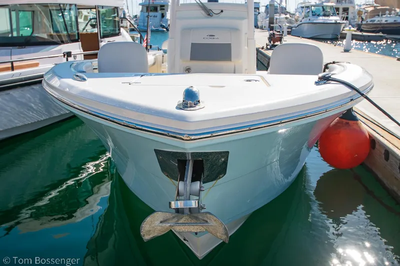 Slide: The Image of 2018 Cobia 240 CC boat docked at marina, front view with anchor visible. - 30