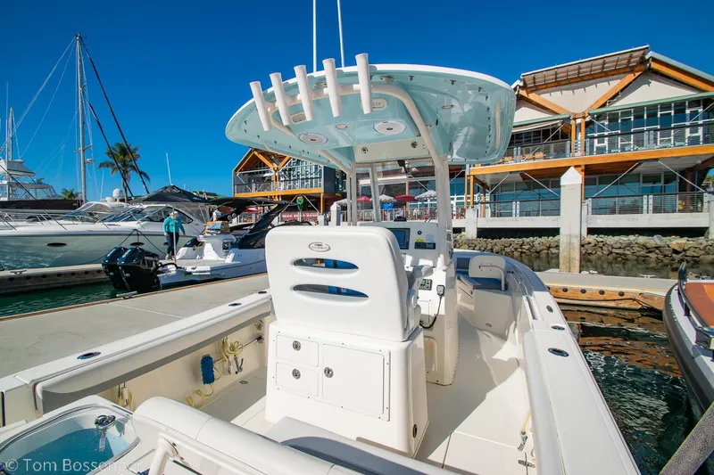 Slide: The Image of 2018 Cobia 240 CC boat docked at marina with modern architecture in background. - 6