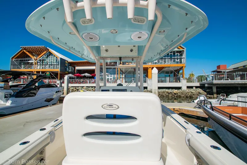 Slide: The Image of 2018 Cobia 240 CC boat docked at marina with modern buildings in background. - 7