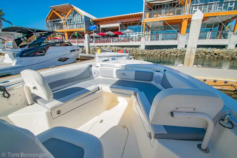 Slide: The Image of 2018 Cobia 240 CC boat docked near modern waterfront buildings. - 9