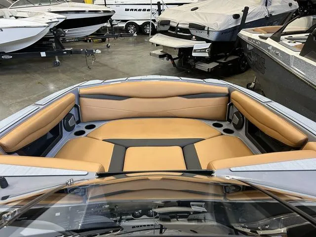 Slide: The Image of 2024 Axis Wake Research A225 boat interior with tan and black seating in showroom. - 10