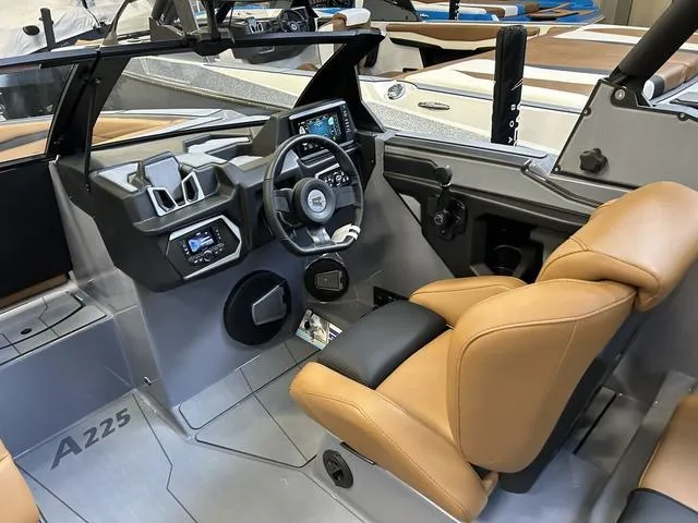 Slide: The Image of 2024 Axis Wake Research A225 boat interior with tan seats and modern dashboard. - 9