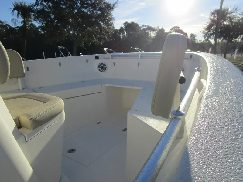 Slide: The Image of 2024 Cobia 240 CC boat interior with seating and railings in sunlight. - 10