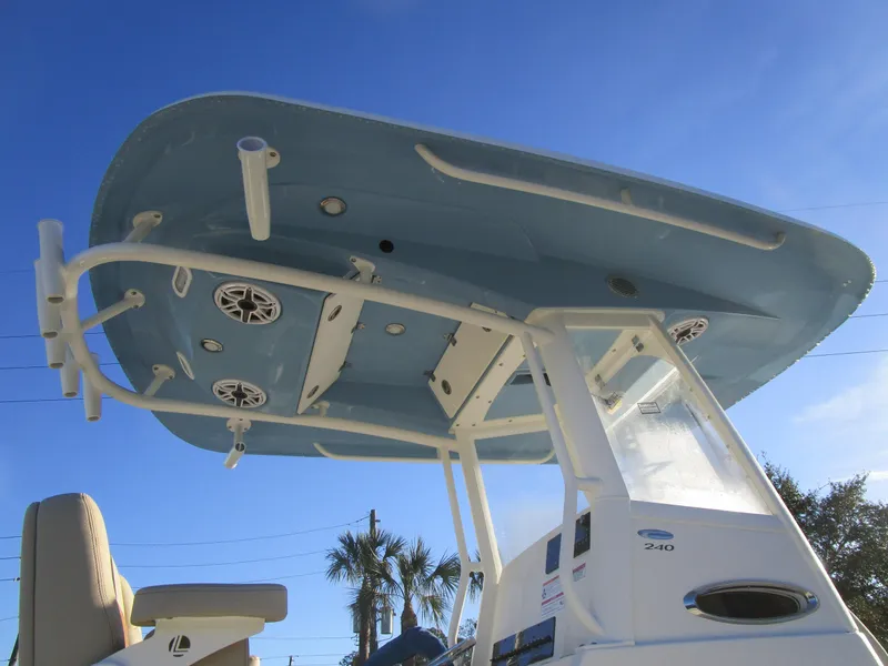 Slide: The Image of 2024 Cobia 240 CC boat with T-top and speakers against blue sky. - 9