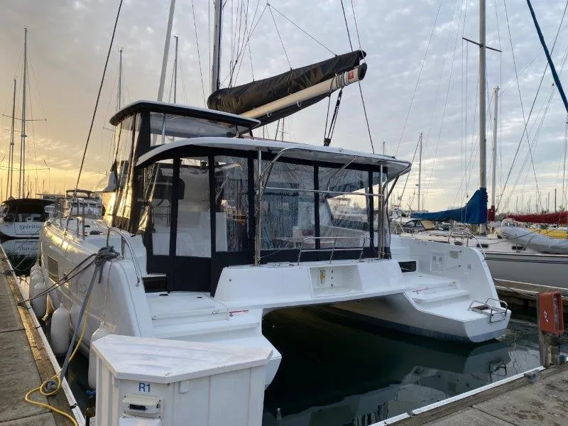 Slide: The Image of 2024 Lagoon 42 catamaran docked at marina during sunset. - 24