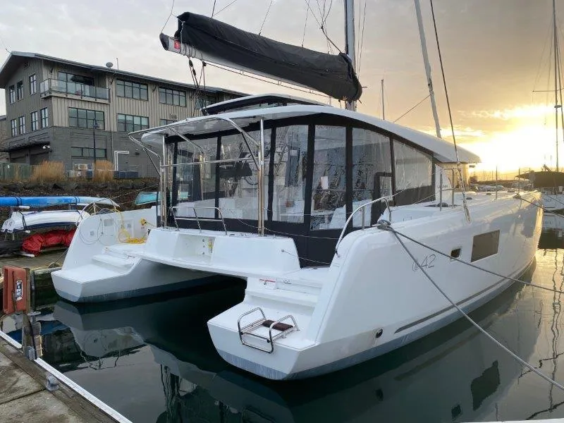 Slide: The Image of 2024 Lagoon 42 catamaran docked at marina during sunset. - 25