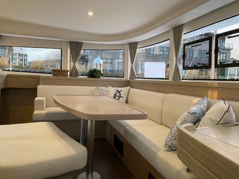 Slide: The Image of Interior of 2024 Lagoon 42 catamaran with modern seating and dining area. - 5