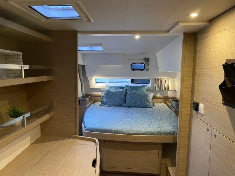 Slide: The Image of 2024 Lagoon 42 catamaran interior cabin with bed and skylights. - 6