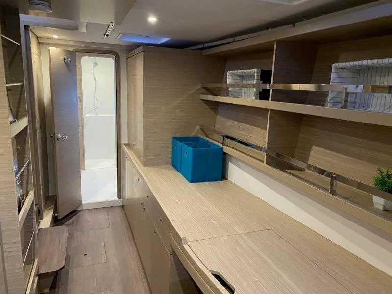 Slide: The Image of Interior of 2024 Lagoon 42 catamaran with modern wooden cabinetry and shelving. - 8