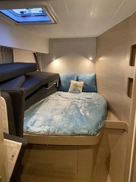 Slide: The Image of Modern bedroom interior of 2024 Lagoon 42 catamaran with skylight and cozy bedding. - 16