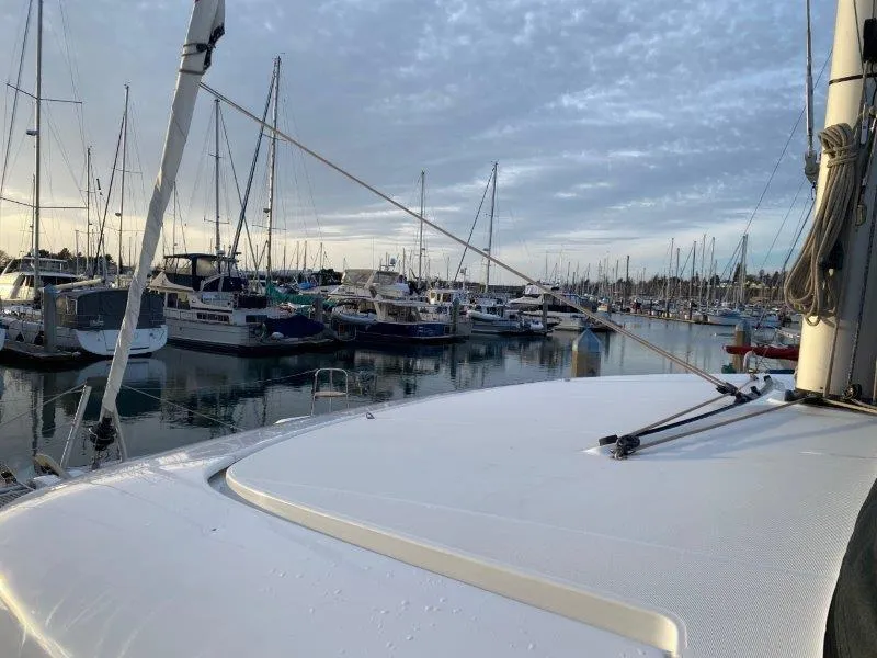 Slide: The Image of 2024 Lagoon 42 catamaran docked in a marina with other boats. - 22