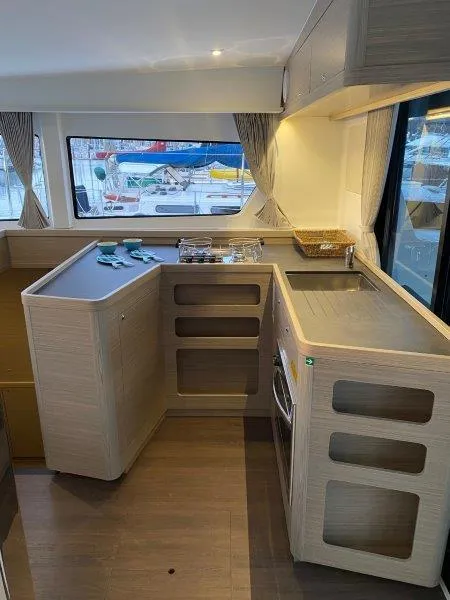 Slide: The Image of Modern kitchen area in 2024 Lagoon 42 catamaran with ample counter space and large windows. - 3