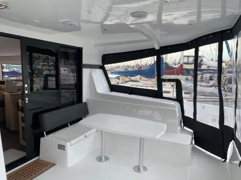 Slide: The Image of 2024 Lagoon 42 yacht interior with seating and table, docked at marina. - 32