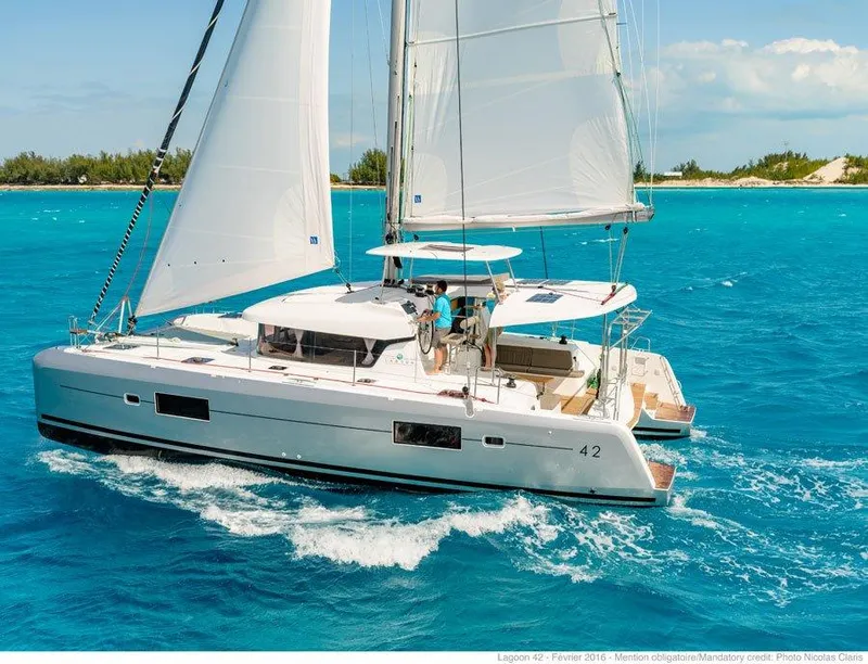 Slide: The Image of 2024 Lagoon 42 catamaran sailing in turquoise waters near a tropical island. - 37