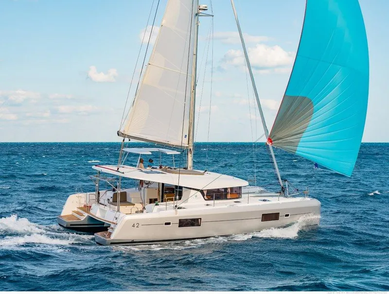 Slide: The Image of 2024 Lagoon 42 catamaran sailing on open sea with blue spinnaker. - 42
