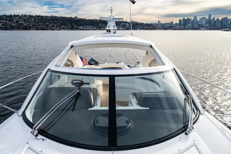 Slide: The Image of 2007 Sunseeker Portofino 47 yacht on calm water with city skyline in the background. - 10